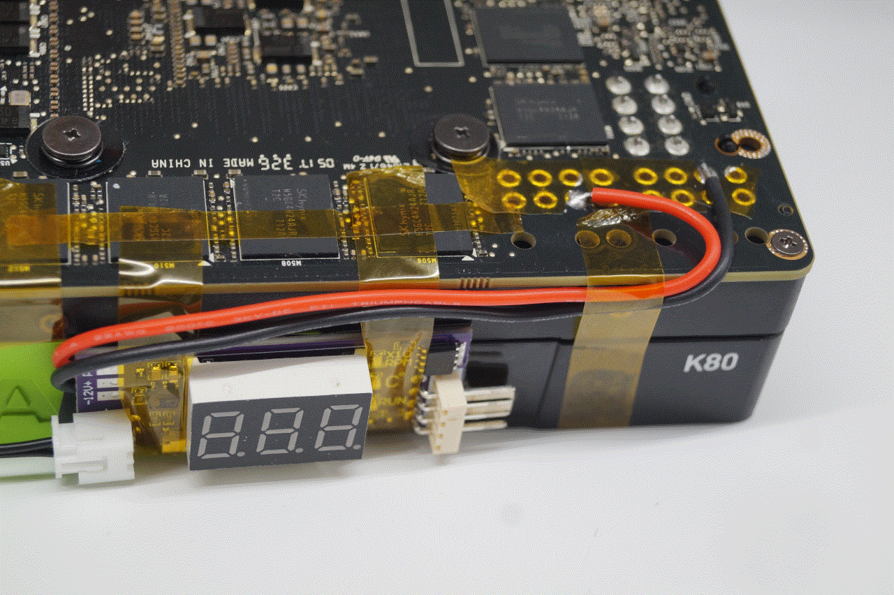 An image showing the +12V and GND wires of the PWM fan controller affixed to unpopulated power pins on the K80